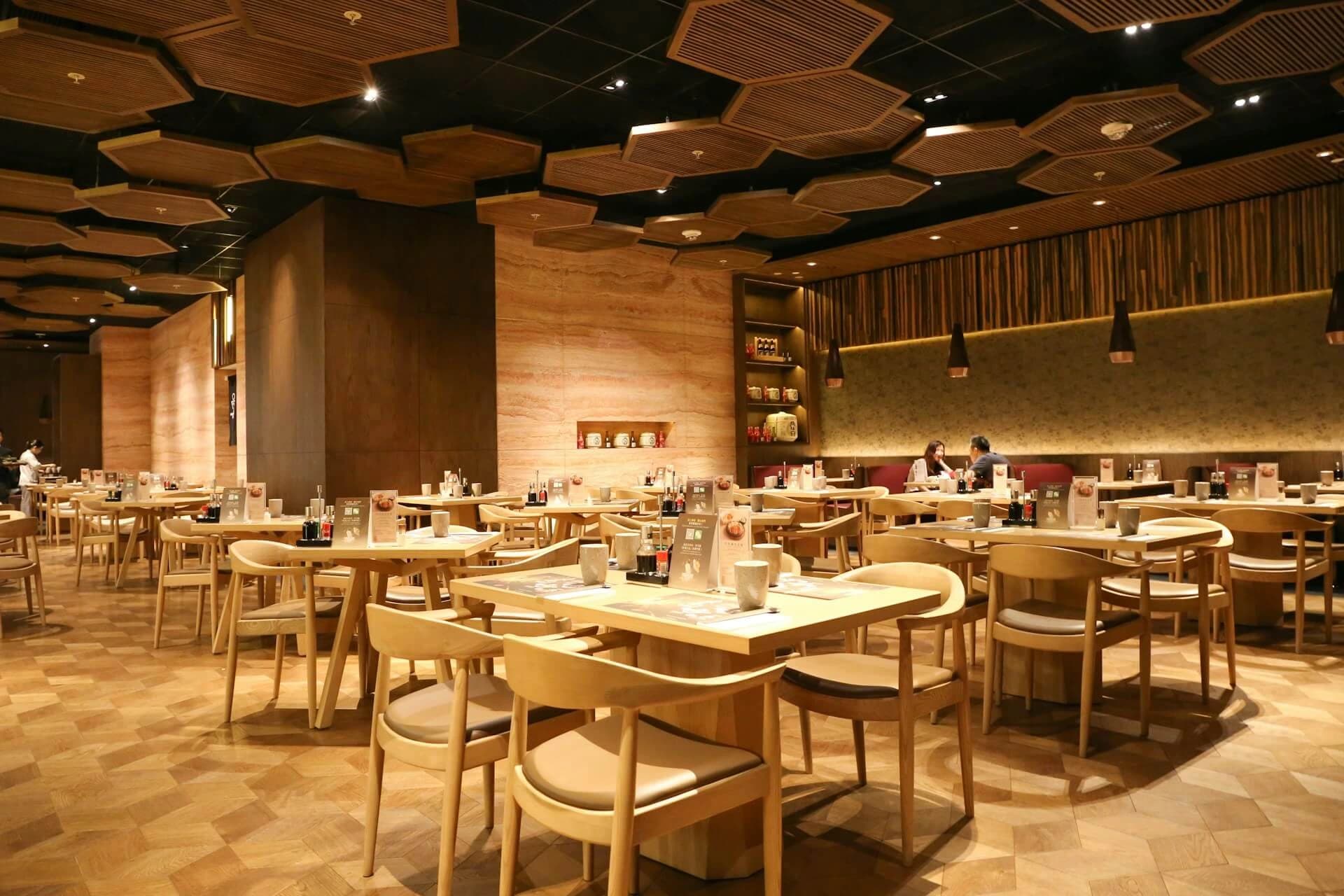 Warmly lit Velveta dining room with wooden chairs and set tables